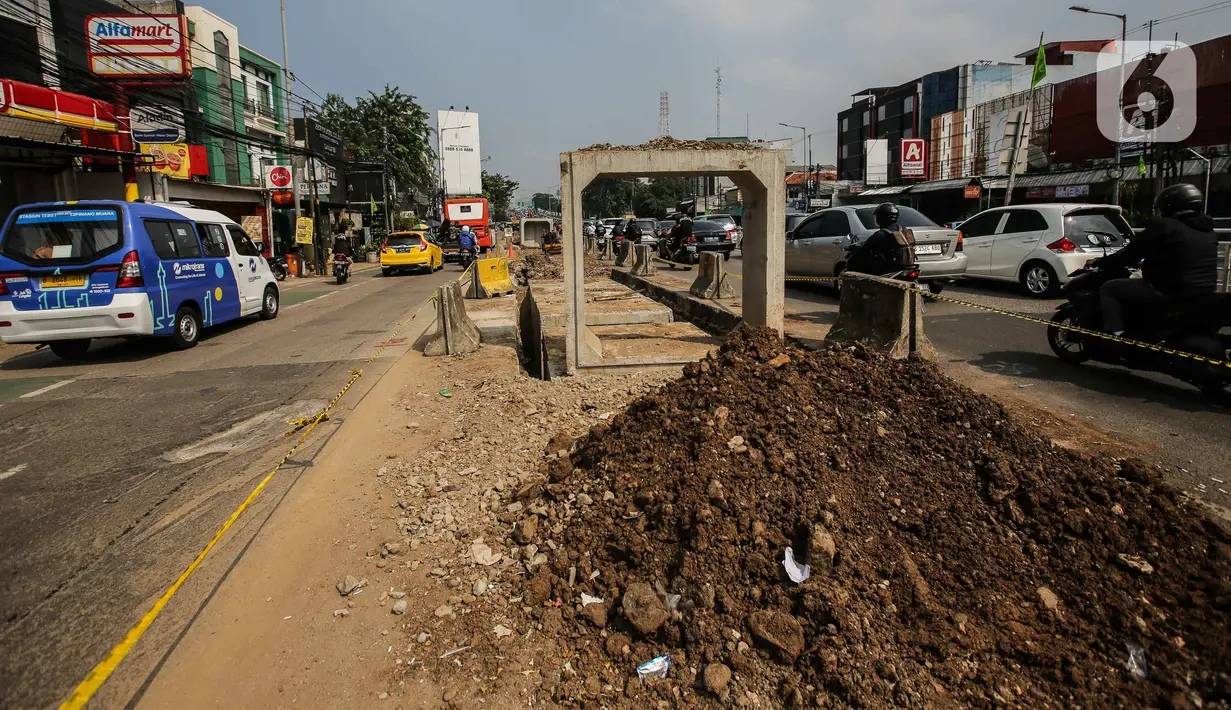 Pengendara melintas di dekat proyek pembangunan saluran air atau drainase di Jalan KH Abdullah Syafei, Jakarta, Selasa (18/7/2023). (Liputan6.com/Faizal Fanani)