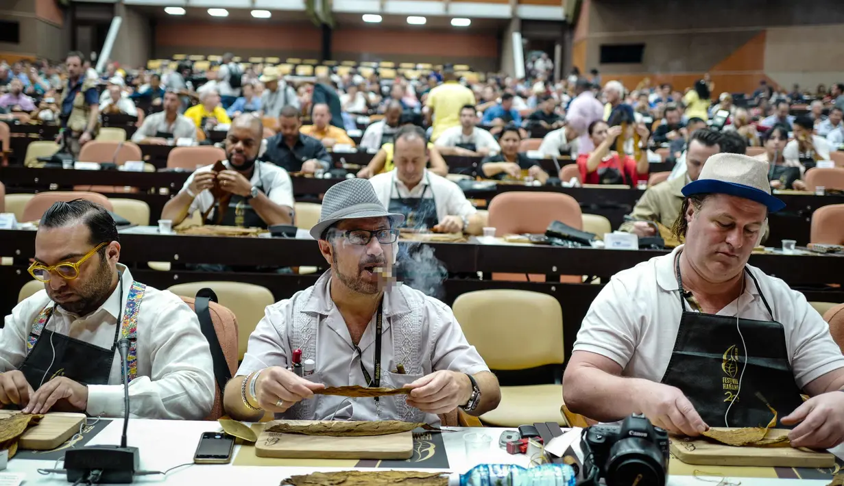Sejumlah peserta menggulung cerutu selama kelas master dalam Festival Havana Cigar ke-20 di Istana Konvensi di Havana, Kuba (28/2). (AFP Photo/Adalberto Roque)