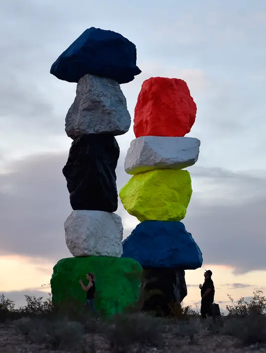Pengunjung menikmati instalasi seni yang berjudul ' Seven Magic Mountains' di dekat Jean , Nevada, 14 Mei 2016. Proses pembuatan tujuh menara mirip mainan anak ini selam lima tahun. (David Becker / AFP)
