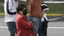 Kerabat menemani dan anggota keluarga lanjut usia saat dia mengantre untuk disuntik vaksin Covid-19 di luar pusat vaksinasi Social Security Institute di Quito, Ekuador, Kamis (6/5/2021). Para lansia dan pendampingnya menunggu berjam-jam untuk divaksinasi. (AP Photo/Dolores Ochoa)