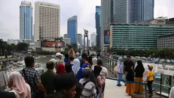 Di pusat kota Jakarta, warga bisa berwisata dengan berfoto berlatar gedung-gedung tinggi dan salah satu monumen ikonik, yakni patung selamat datang. (Liputan6.com/Angga Yuniar)