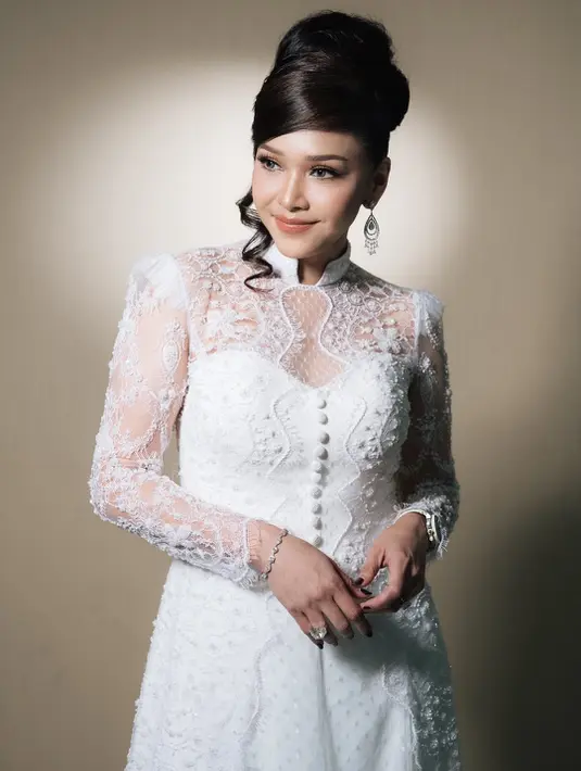 Detail bordir floral dan aksen kancing di bagian depan membuat tampilannya terasa klasik seperti gaun bridal couture. Material lace transparan itu juga memberi dimensi lembut yang membuat keseluruhan look terlihat mahal. z[@maiaestiantyreal].