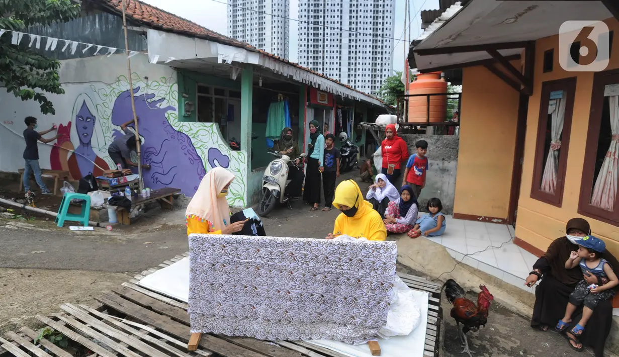 Warga menyelesaikan pembuatan batik tulis saat pelaksanaan kegiatan mural Raincity Strike #8 di Kampung Batik Cibuluh, Bogor, Minggu (22/11/2020). Kegiatan seni mural ini bertujuan diantaranya pengembangan kampung batik sebagai destinasi wisata dengan seni mural. (merdeka.com/Arie Basuki)