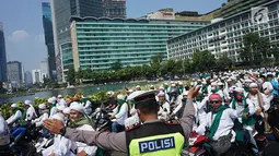 Anggota kepolisian mengatur arus lalu lintas saat rombongan bermotor dari laskar Front Pembela Islam (FPI)  melintas di kawasan Bundaran HI, Jakarta, Rabu (22/5/2019). Massa aksi 22 Mei akan mulai memadati sekitar Bawaslu selepas Dzuhur. (Liputan6.com/Immanuel Antonius)