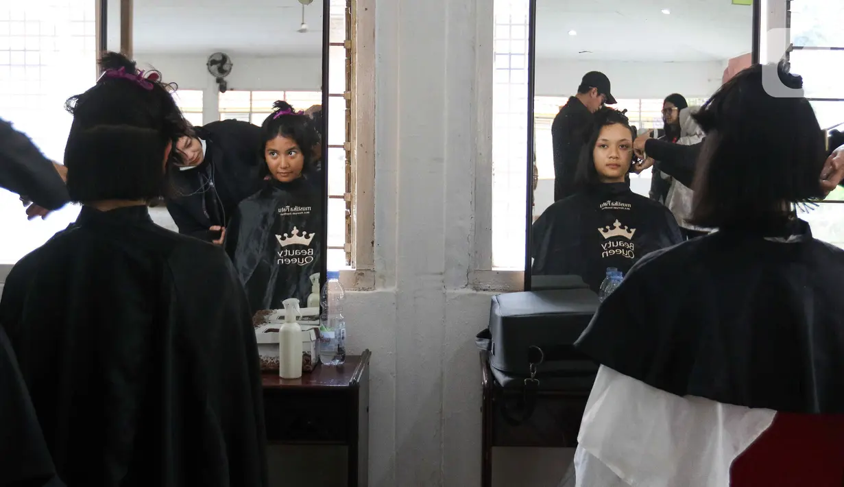 Pasukan Pengibar Bendera Pusaka (Paskibraka) melakukan prosesi potong rambut saat pemusatan diklat Paskibraka 2024 di Jakarta, Minggu (14/7/2024). (Liputan6.com/Herman Zakharia)