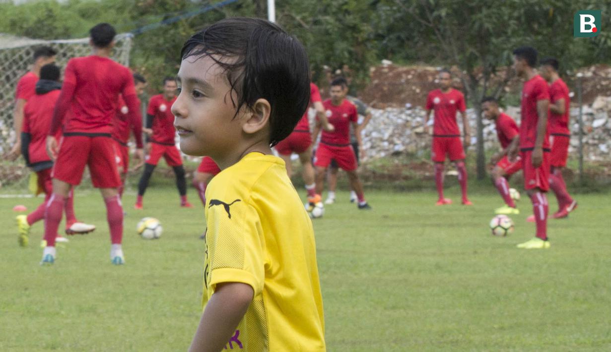 Anak dari Stefano Teco, yang bernama Romario, bermain saat latihan Persija Jakarta di Lapangan Sutasoma, Jakarta, Minggu (25/2/2018). Ketika ayahnya bekerja sang anak asyik bermain sepak bola. (Bola.com/Aspirilla Dwi Adha)