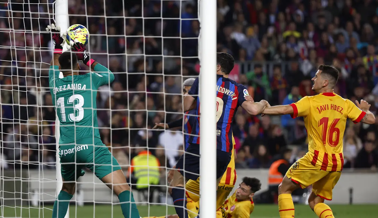 Kiper Girona, Paulo Gazzaniga berhasil mementahkan tandukan bek Barcelona, Ronald Araujo dari sekma sepak pojok pada laga lanjutan pekan ke-28 Liga Spanyol 2022/2023 di Camp Nou Stadium, Barcelona, Selasa (11/4/2023) dini hari WIB. (AP Photo/Joan Monfort)