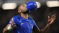 Pemain Chelsea, Christopher Nkunku melakukan selebrasi dengan meniup balon setelah mencetak gol ke gawang Southampton dalam laga lanjutan Liga Inggris 2024/2025 di Stamford Bridge, London, Rabu (26/02/2025) WIB. (AP Photo/John Walton)