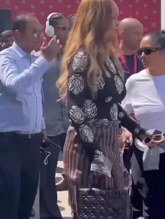 Rihanna tampil kasual nyentrik dengan padu padan atasan lengan panjang bermotif penuh, celana kargo ungu, dan rok di atasnya.  Ia melengkapi penampilannya dengan sepasang sepatu hak runcing berwarna putih dan tas Dior berwarna hitam.  [@nounouche.online/@rihannadaily]