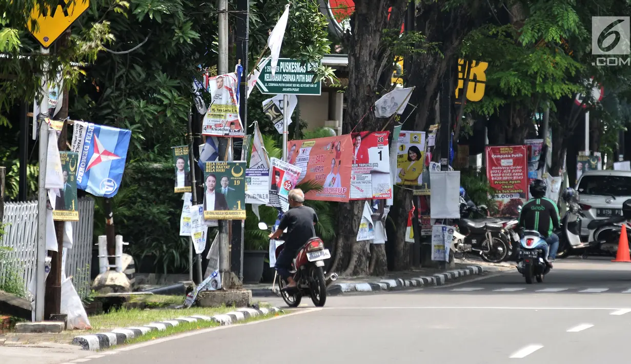 Sejumlah alat peraga kampanye (APK) calon anggota legislatif (caleg) memenuhi pepohonan yang berada di pinggir jalan, Jakarta, Rabu (20/3). Pemasangan APK tersebut melanggar aturan PKPU Nomor 23 Pasal 31 Tentang Bahan Kampanye. (merdeka.com/Iqbal Nugroho)