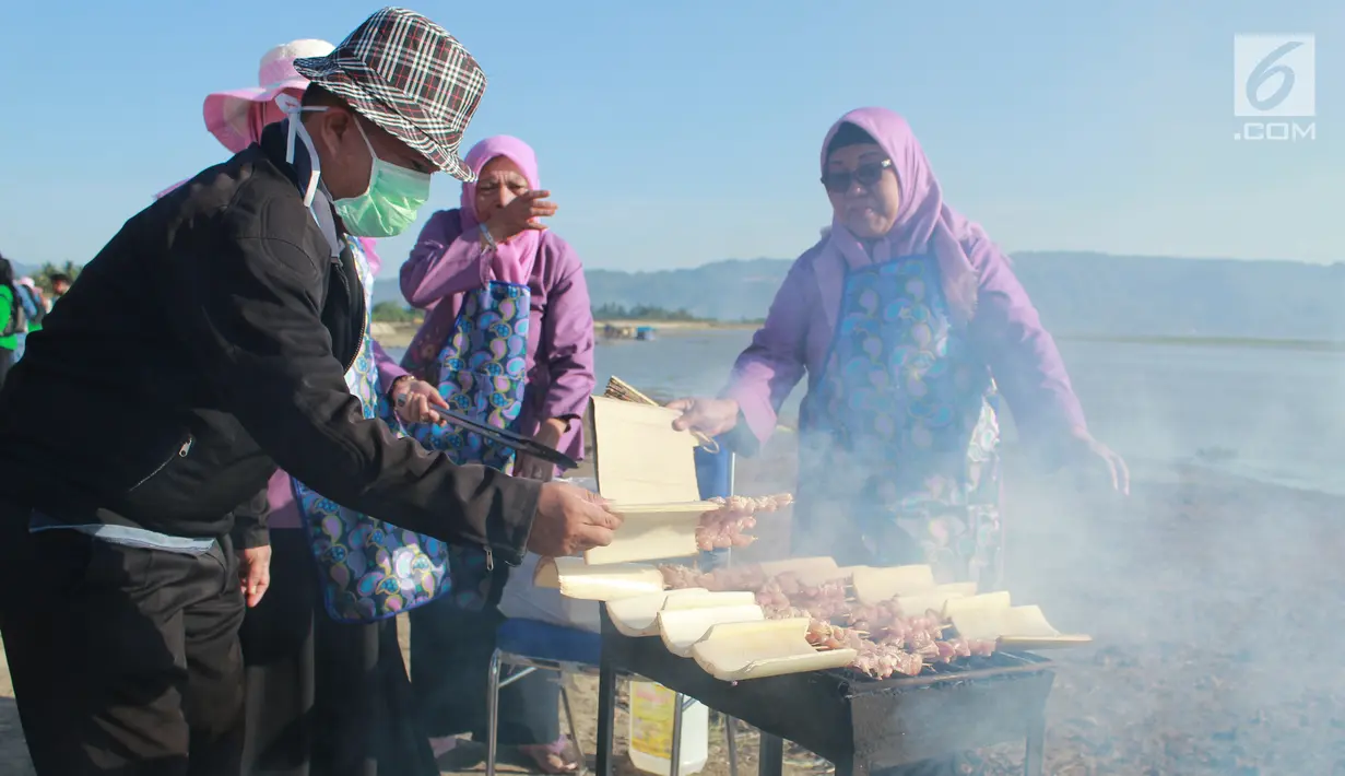 Sejumlah anggota Dharma Wanita Persatuan (DWP) membakar sate dalam memeriahkan Festival Pesona Danau Limboto, Gorontalo, Senin (24/9). MURI mencatat sebanyak 88.950 tusuk sate disajikan secara gratis oleh Pemkab Gorontalo. (Liputan6.com/Arfandi Ibrahim)