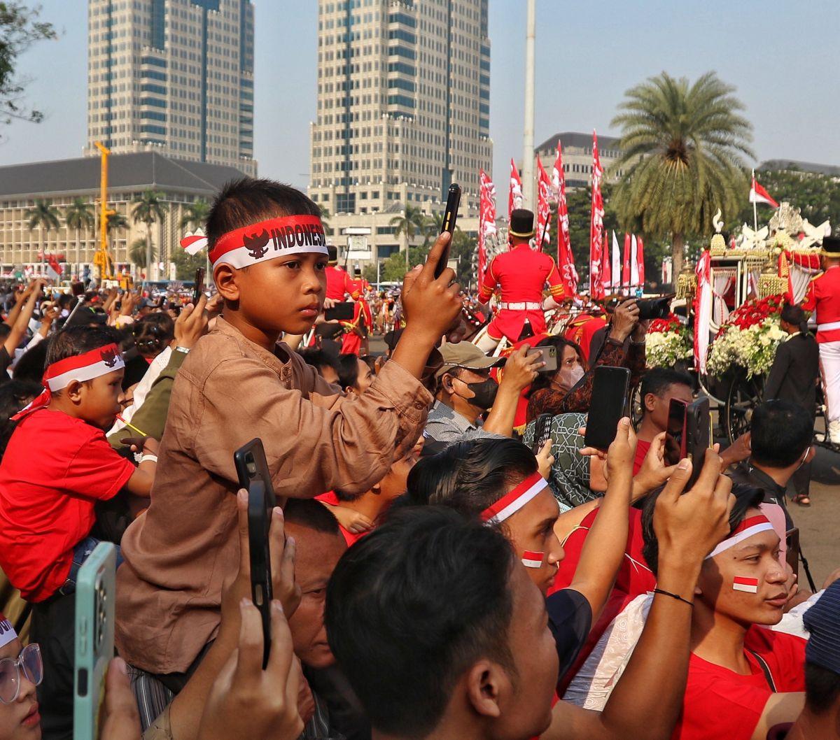 Masyarakat yang hadir di sini pun tampil dengan memakai pernak-pernik bernuansa merah putih 17 Agustus.

Salah satunya seperti kain ikat kepala merah putih ini. Mereka memakainya selama menyaksikan kirab.