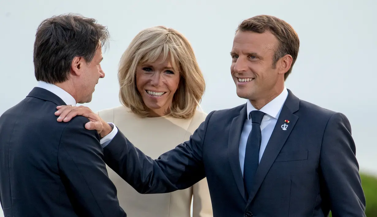 Presiden Prancis Emmanuel Macron (kanan) dan istrinya Brigitte Macron (tengah) menyambut kedatangan pemimpin sementara Italia Giuseppe Conte di KTT G7, Biarritz, Prancis, Sabtu (24/8/2019). (AP Photo/Andrew Harnik)