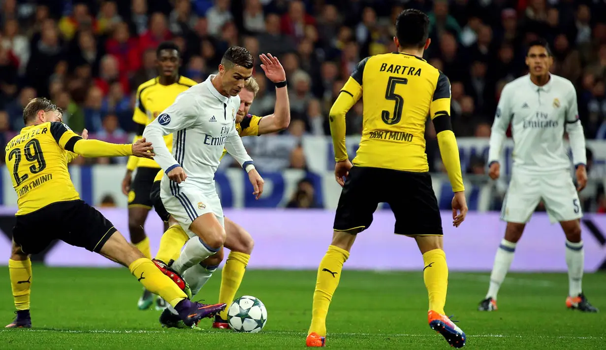 Bintang Real Madrid, Cristiano Ronaldo, berusaha lepas dari hadangan pemain Dortmund. Namun Dortmund akhirnya mampu menyamakan kedudukan menjadi 2-2 berkat gol Pierre-Emerick Aubameyang dan Marco Reus. (Reuters/Susana Vera)