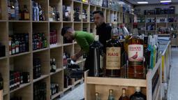Sejumlah pembeli memilih alkohol di sebuah toko minuman keras di Baghdad, Irak, Kamis, 9 Maret 2023. Dalam sebuah pernyataan, Otoritas Umum Bea Cukai Irak mengatakan seluruh titik pabean diperintahkan melarang masuk segala jenis minuman beralkohol. (AP Photo/Hadi Mizban)