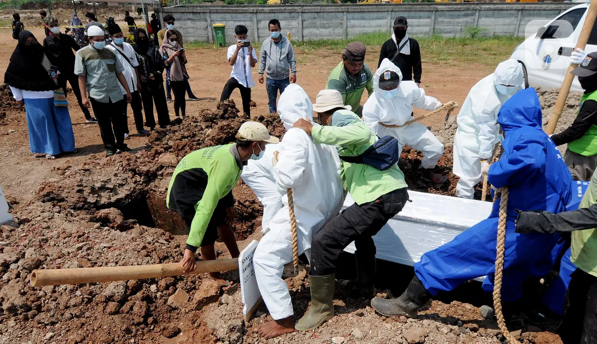 Petugas memakamkan jenazah korban COVID-19 di TPU Rorotan, Cilincing, Jakarta Utara, Kamis (29/4/2021). Dalam sehari, TPU Rorotan memakamkan korban COVID-19 dengan rata-rata 5 hingga 8 jenazah. (merdeka.com/Arie Basuki)