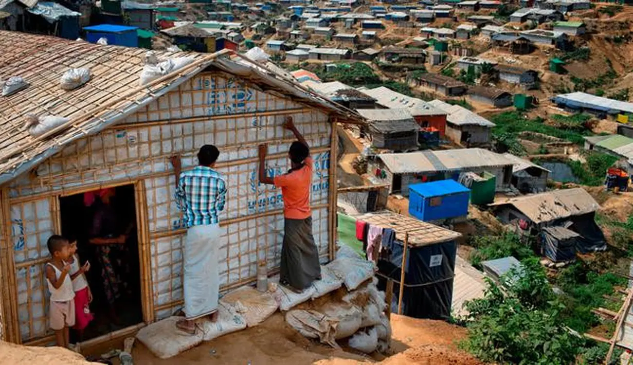 Pengungsi Rohingya memperbaiki rumahnya di Kamp Pengungsi Kutupalong, Bangladesh, 28 April 2018. Apabila hujan tiba, ada ancaman serius kamp pengungsi yang dibangun secara tidak teratur itu mengalami kebanjiran dan longsoran lumpur. (AP Photo / A.M. Ahad)