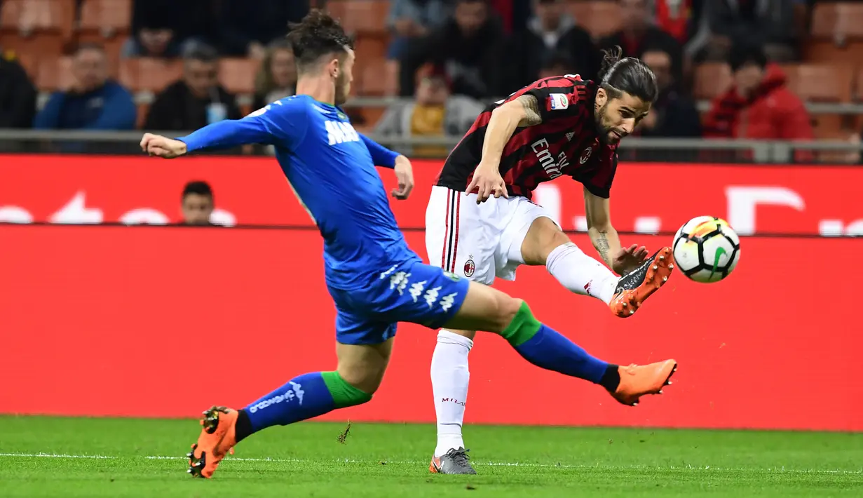 Bek AC Milan, Ricardo Rodriguez berebut bola dengan pemain Sassuolo, Pol Lirola pada laga pekan ke-31 Serie A di San Siro, Minggu (8/4). Sassuolo menahan AC Milan dengan skor 1-1 dalam lanjutan laga Serie A. (AFP PHOTO/MIGUEL MEDINA)