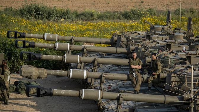 Tentara Israel duduk di atas artileri dekat perbatasan dengan Gaza, Rabu (27/3). Mobilisasi tentara Israel ke perbatasan Gaza dilakukan ketika suasana telah mereda setelah baku tembak dengan kelompok Hamas. (AP Photo/Tsafrir Abayov)