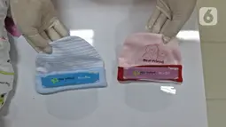 Perawat kamar bayi menunjukkan face shield (italic) di  RSIA Tambak, Jakarta, Selasa (14/4/2020). RSIA Tambak membuat face shield (italic) mandiri menggunakan plastik mika, direkatkan dengan karet atau bandana menggunakan topi bayi menghindarkan alergi pada kulit bayi. (Liputan6.com/Herman Zakharia)