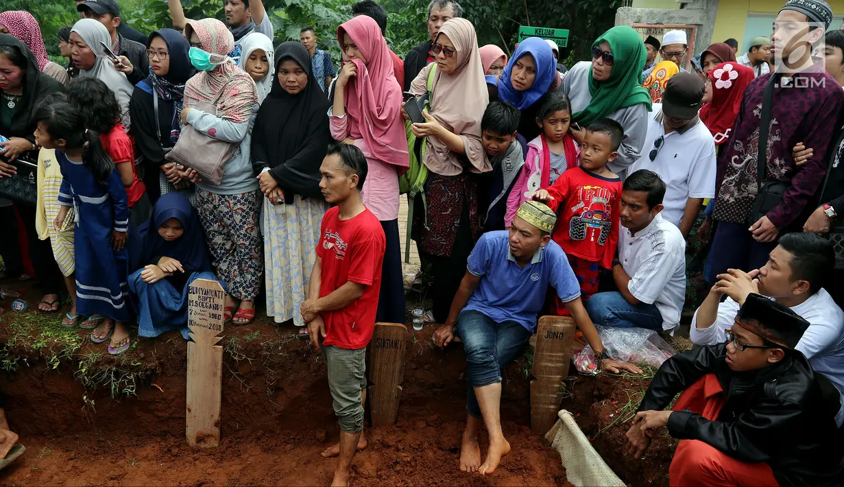 Raut kesedihan keluarga dan kerabat saat pemakaman korban kecelakaan bus di Tanjakan Emen Subang di TPU Legoso Ciputat, Tangerang Selatan, Banten, Minggu (11/2). Polisi masih menyelidiki penyebab kecelakaan maut tersebut. (Liputan6.com/JohanTallo)