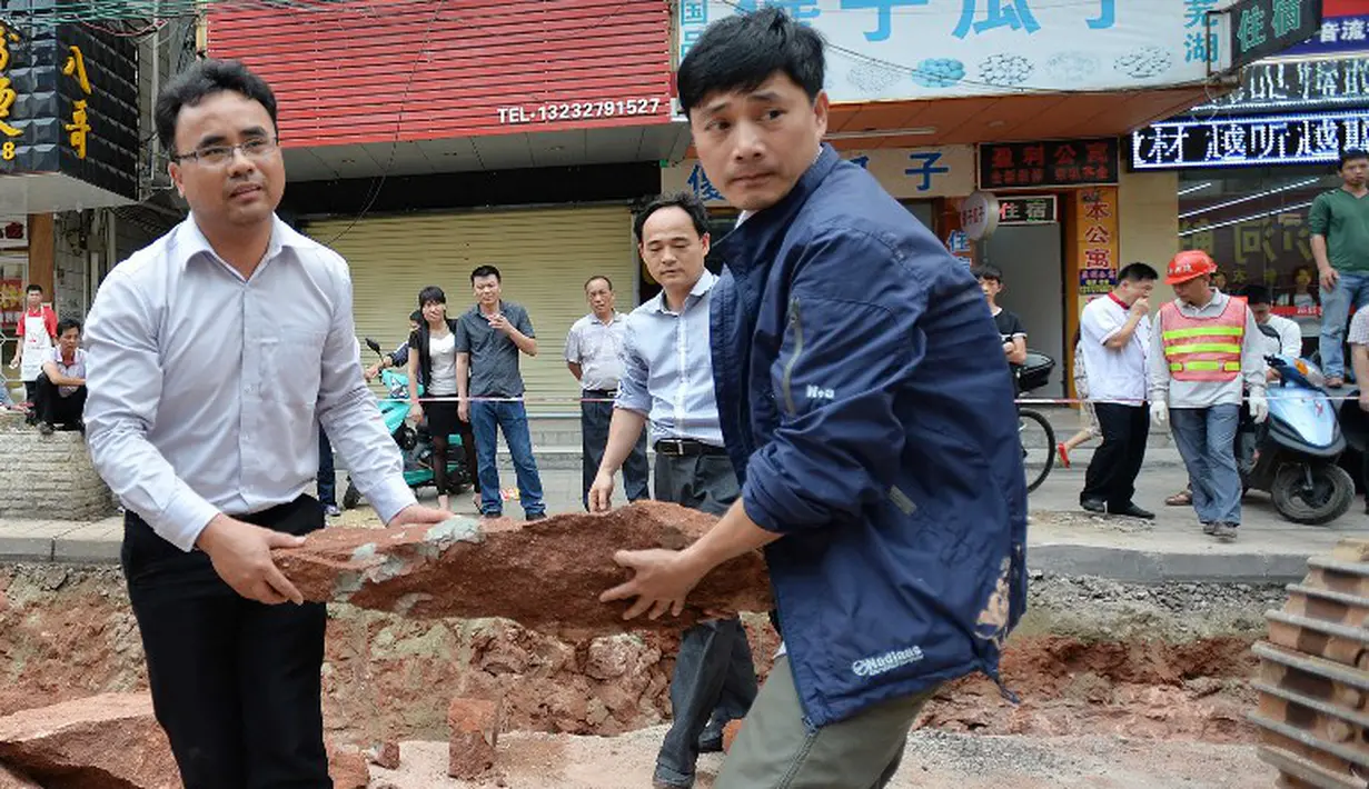 Sejumlah petugas mengangkat fosil telur Dinosaurus , Heyuan, Tiongkok, Kamis (23/4/2015). Telur dibawa untuk diteliti oleh para ahli dari Heyuan Dinosaur Museum (AFP Photo/China Out)