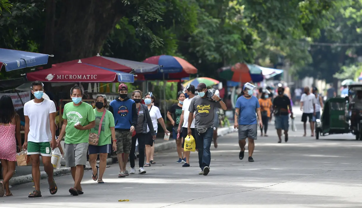 Orang-orang tiba di pemakaman untuk mengunjungi makam kerabat mereka di Manila, Filipina (28/10/2021). Pemerintah setempat akan menutup pemakaman nasional untuk Hari Semua Orang Kudus karena pandemi virus corona Covid-19. (AFP/Ted Aljibe)