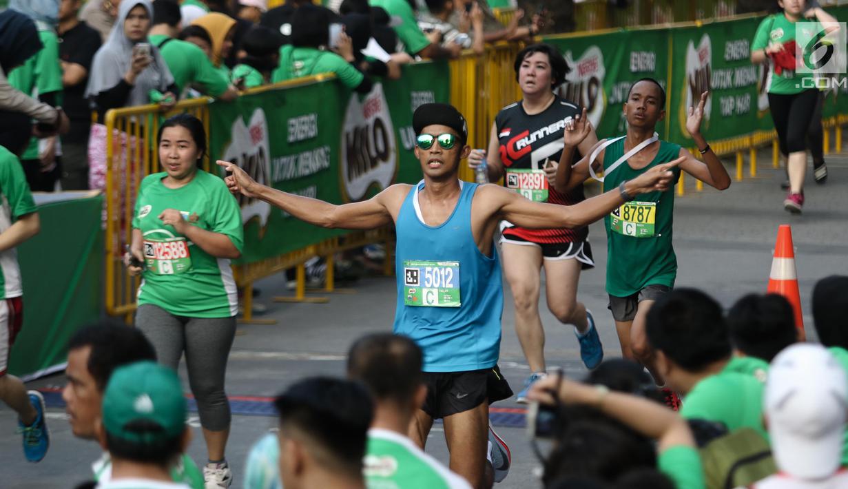 Ekpresi peserta Lomba lari MILO Jakarta International 10K 2017 saat sampai di garis finis, Jakarta, Minggu (23/7). MILO Jakarta International 10K 2017 melombakan tiga kategori yakni 10K, 5K dan Family Run 1,7K. (Liputan6.com/Faizal Fanani)