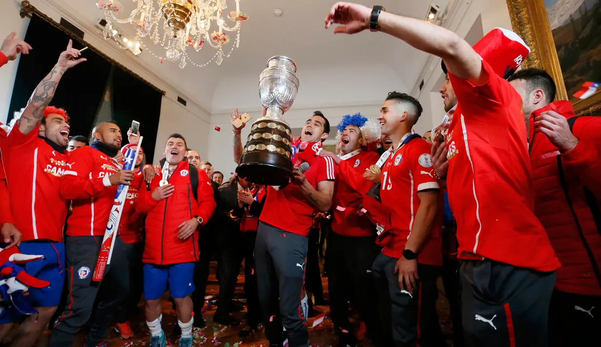 Sejumlah pemain Chili bersorak bergembira mengangkat trofi usai mengalahkan Argentina di final Copa America 2015 di Istana nasional, Chili (4/7/2015). Chili menang lewat adu penalti atas Argentina dengan skor 4-1. (REUTERS/Rodrigo Garrido)