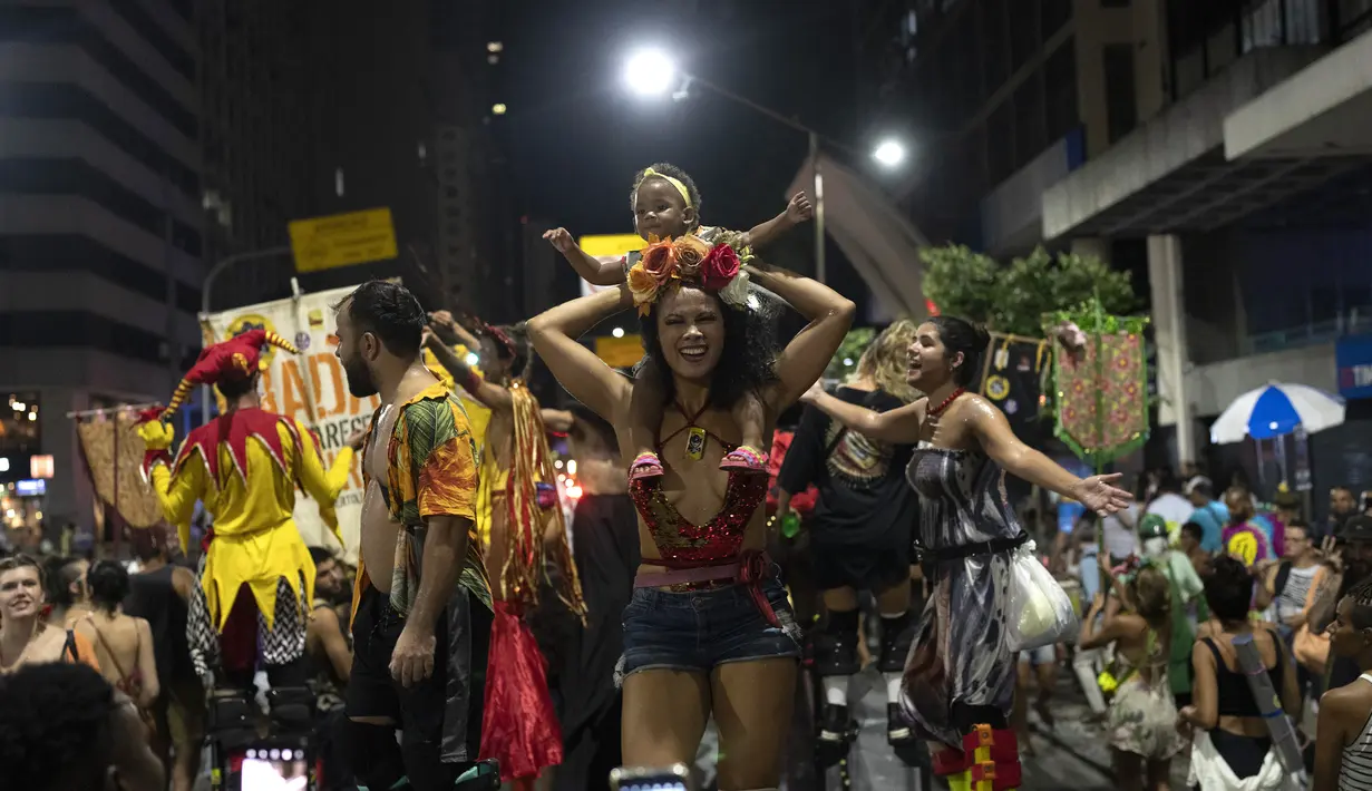 Peserta pesta jalanan yang dikenal sebagai blocos, menari selama protes terhadap pembatasan oleh pejabat kota di Rio de Janeiro, Brasil (13/4/2022). Balai Kota telah melarang pesta jalanan selama perayaan Karnaval, yang tertunda hampir dua bulan karena pandemi. (AP Photo/Silvia Izquierdo)