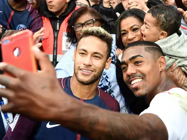 Penyerang PSG, Neymar berfoto bersama dengan pemain Bordeaux, Malcom usai pertandingan Ligue 1 di stadion Parc des Princes di Paris (30/9). Kedua pemain asal Brasil ini terlihat akrab usai pertandingan.  (AFP Photo/Franck Fife)