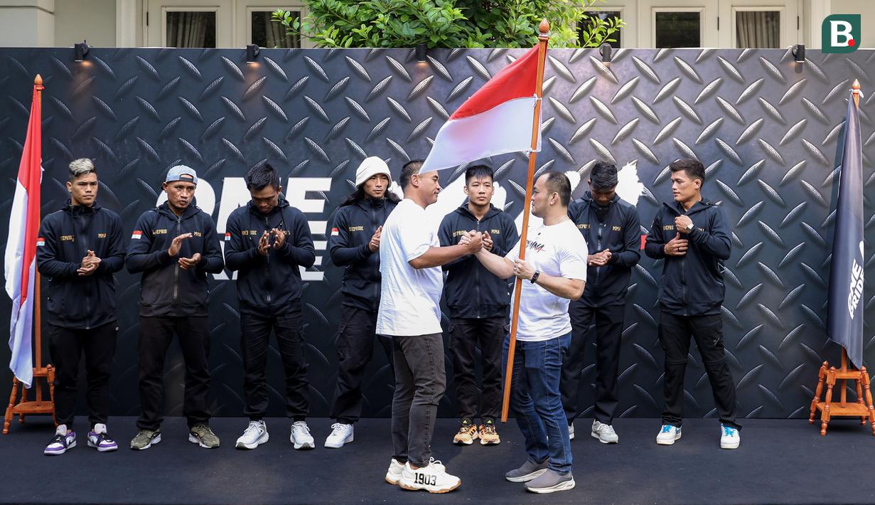 Ketua Umum Komite Olahraga Beladiri Indonesia (KOBI), Ardi Bakrie menyerahkan bendera merah putih sebagai simbol pelepasan saat konferensi pers mengenai pemberangkatan atlet MMA ke China yang berlangsung di Menteng, Jakarta Pusat, Senin (21/10/2024). (Bola.com/Bagaskara Lazuardi)