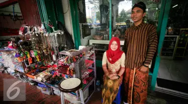 PKL wanita dan pria berpose di emperan toko kawasan Malioboro mengenakan pakaian tradisional, Rabu (20/4/2016). Sejumlah PKL mengenakan pakain adat jawa menyambut hari Kartini 21 April besuk. (Liputan6.com/Boy Harjanto)