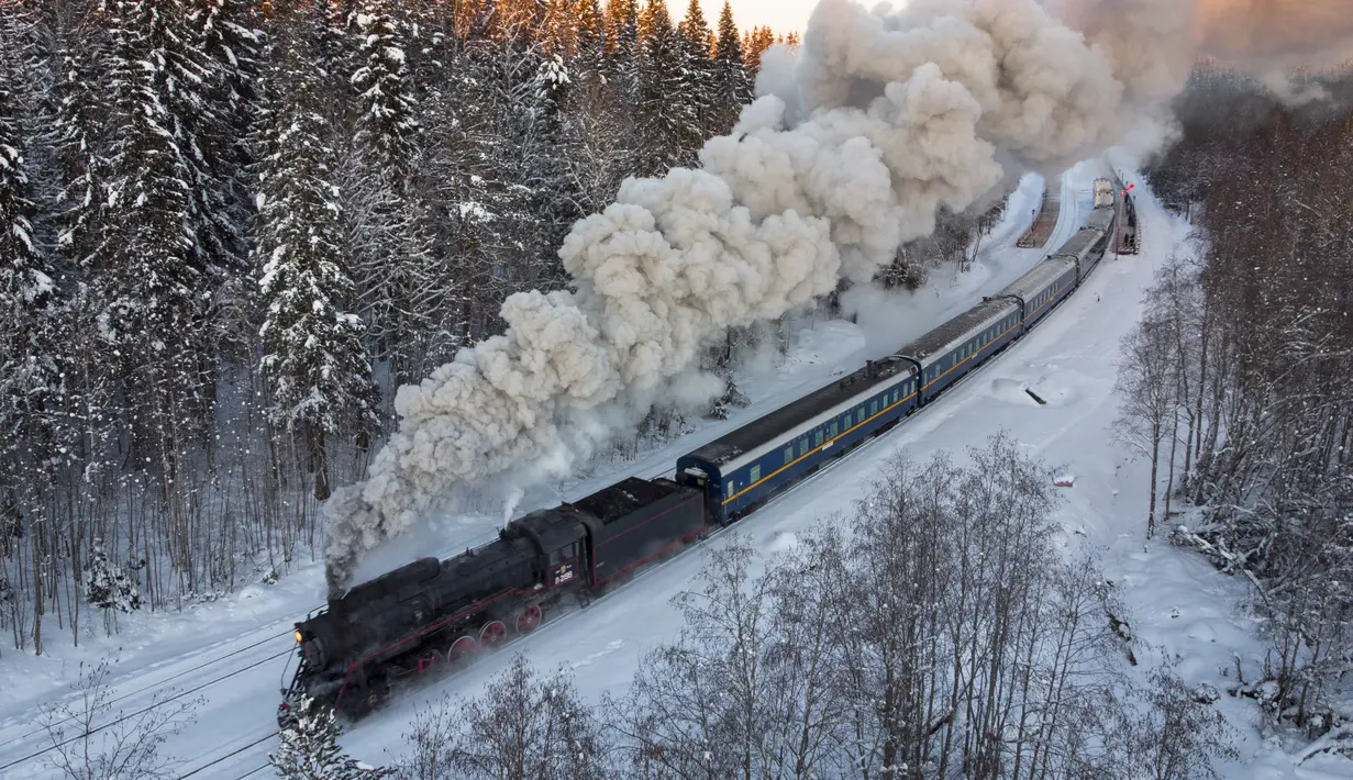 Sebuah lokomotif uap era Soviet menarik kereta retro di taman alam Ruskeala, sekitar 200 km (125 mil) di utara St. Petersburg, Rusia (17/2/2021). Kereta retro bertenaga uap tersebut beroperasi setiap hari di perbatasan Rusia dengan Karelia. (AP Photo/Dmitri Lovetsky)