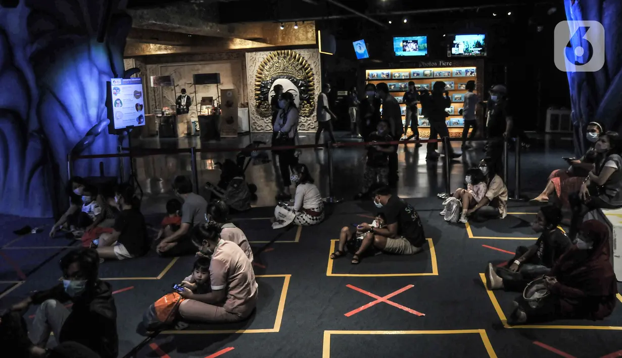 Pengunjung duduk dengan menerapkan protokol kesehatan saat menyaksikan pertunjukan bawah air di Jakarta Aquarium & Safari (JAQS), Neo Soho Mall, Jakarta, Rabu (21/4/2021). JAQS sekaligus mengedukasi anak-anak tentang ekosistem biota laut dan air tawar. (merdeka.com/Iqbal S. Nugroho)