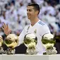 Bintang Real Madrid, Cristiano Ronaldo, berpose dengan kelima trofi Ballon d'Or di Stadion Santiago Bernabeu, Sabtu (9/12/2017). Cristiano Ronaldo meraih Ballon d'Or 2017 setelah unggul dari Lionel Messi dan Neymar. (AFP/Pierre-Philippe Marcou)