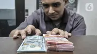 Pegawai menunjukkan uang rupiah dan dolar AS di salah satu gerai money changer di Jakarta, Senin (4/7/2022). Melansir data Refinitiv, hingga 4 Juni 2022 pukul 11:10 WIB rupiah melemah 0,15 persen ke Rp14.957 per USD 1. (merdeka.com/Iqbal S Nugroho)