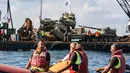 Aktivis lingkungan menurunkan tank lama ke dasar Laut Mediterania di lepas pantai kota pelabuhan Sidon, Lebanon, Sabtu (28/7). Mereka menenggelamkan 10 tank lama yang yang merupakan hadiah  dari Angkatan Bersenjata Lebanon. (AFP / Mahmoud ZAYYAT)
