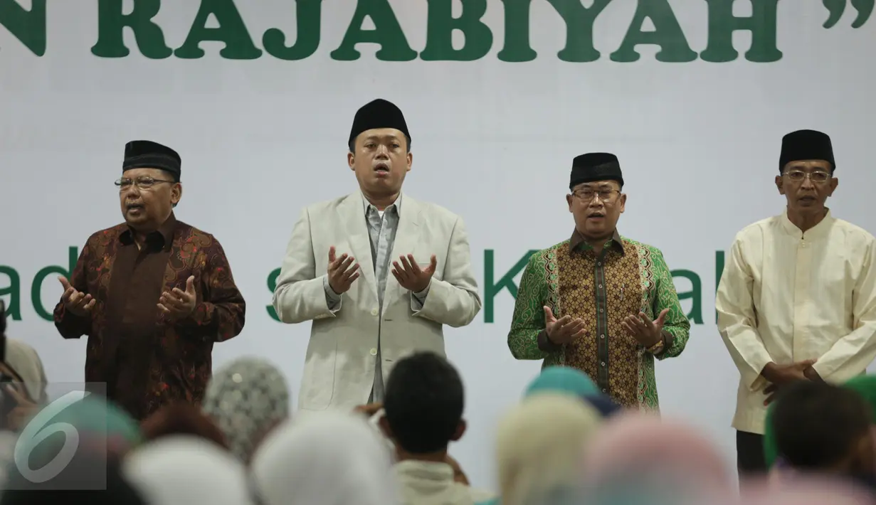 Tokoh Muda NU, H. Nusron Wahid (kedua kiri) berdoa saat mengikuti pengajian umum peringatan Rajabiyah, Jakarta, Minggu (2/4). Sebanyak 2500 masyarakat madura yang berada di Jakarta hadir untuk mengikuti pengajian umum. (Liputan6.com/Faizal Fanani)
