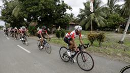 Tim Indonesia  melewati halaman rumah warga yang memajang bendera Merah-Putih menyambut HUT RI ke-71 pada ajang balapa Tour de Singkarak 2016 di Sumatera Barat, (11/8/2016). (Bola.com/Nicklas Hanoatubun)