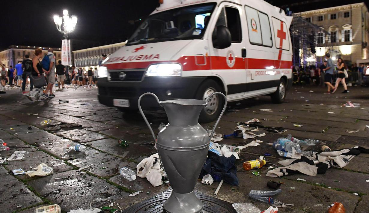Mobil ambulans berusaha mengevakuasi korban usai terjadi ledakan saat nonton bareng final Liga Champions di Piazza San Carlo, Turin, Sabtu (3/6/2017). Acara nobar dipadati sekitar 20.000 supporter Juventus. (AP/Alessandro Di Marco)