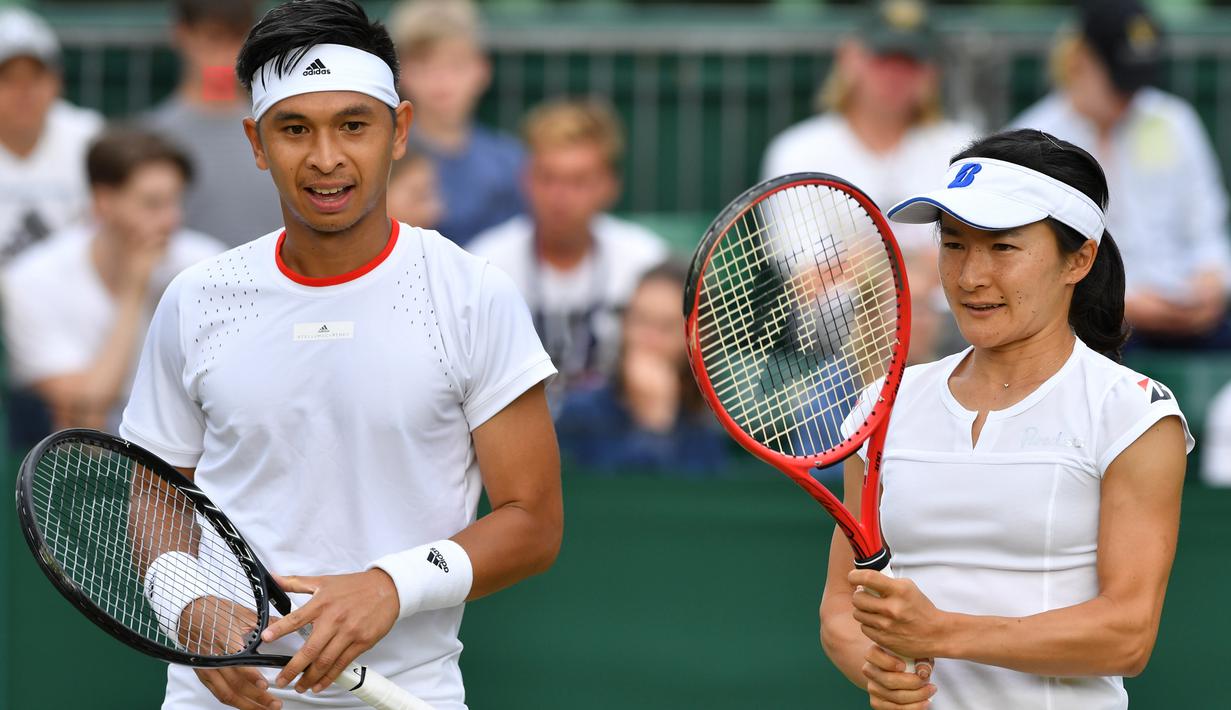 Petenis Indonesia Christopher Rungkat dan Shuko Aoyama dari Jepang bersiap melawan petenis Kroasia Nikola Mektic dan Alicja Rosolska dari Polandia pada putaran kedua ganda campuran Wimbledon 2019 di All England Lawn Tennis Club, Senin (8/7/2019). Christo/Aoyama kalah 5-7, 4-6. (GLYN KIRK/AFP)