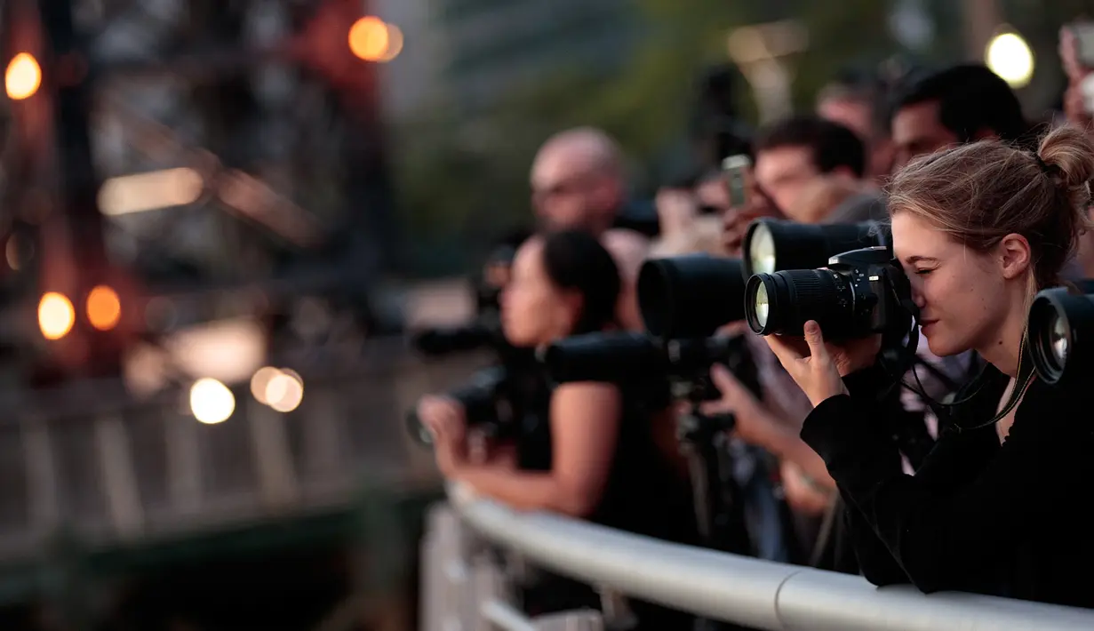 Sejumlah wisatawan mengabadikan fenomena Manhattanhenge di New York, AS, Senin (11/7). Matahari terbit dan terbenam dalam garis lurus di jalan utama Manhattan. Uniknya, sunset semacam ini hanya ada pada musim panas. (Drew Angerer / Getty Images / AFP)