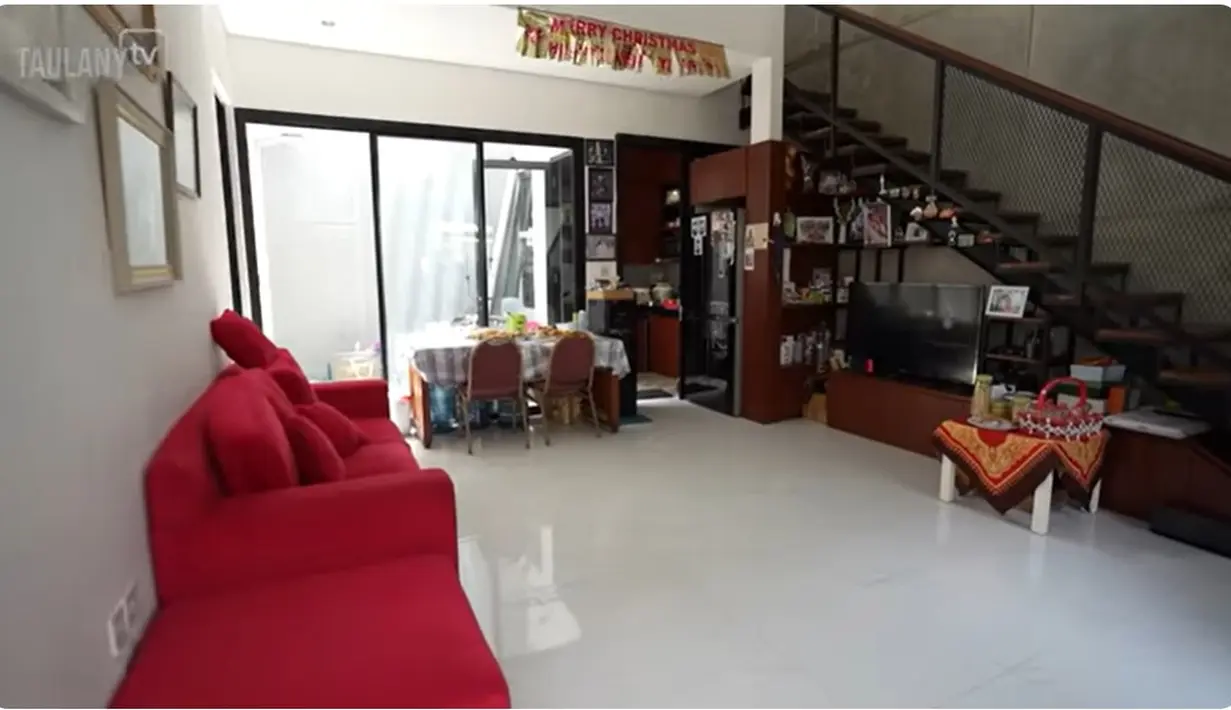 Masuk ke dalam, tampak luas karena tidak banyak sekat. Dilantai ini juga ada satu kamar yang digunakan adiknya. Sofa merah biasa digunakan santai bersama keluarganya. [Youtube/TAULANY TV]