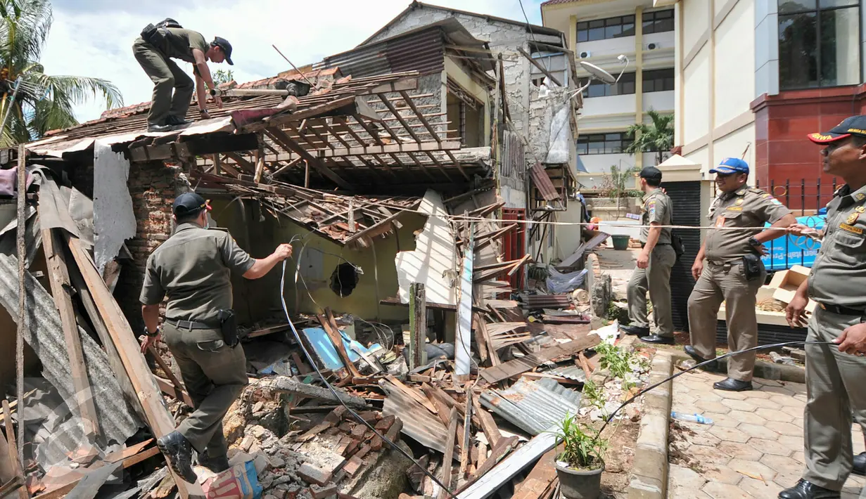 Anggota Satpol PP merobohkan bangunan rumah petak tepat di samping Kantor Kelurahan Rawajati, Pancoran, Jakarta, Selasa (22/12). Empat rumah petak dibongkar oleh Satpol PP karena berdiri di atas lahan milik Pemprov DKI Jakarta. (Liputan6.com/Yoppy Renato)