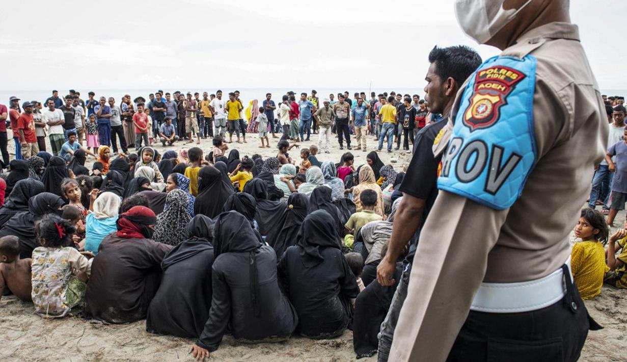 Sementara warga setempat berbondong-bondong datang ke lokasi melihat ratusan pengungsi Rohingya tersebut. Warga ikut membantu memberikan makanan dan minuman. (Jon S./AFP)