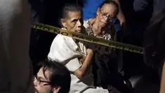 Dua orang lansia dievakuasi ke tempat yang lebih aman usai kebakaran di sebuah panti jompo swasta di Caracas, Venezuela, Minggu (23/8/2015) waktu setempat. Delapan orang penghuni panti tewas dalam peristiwa tersebut. (AFP PHOTO/JUAN BARRETO)