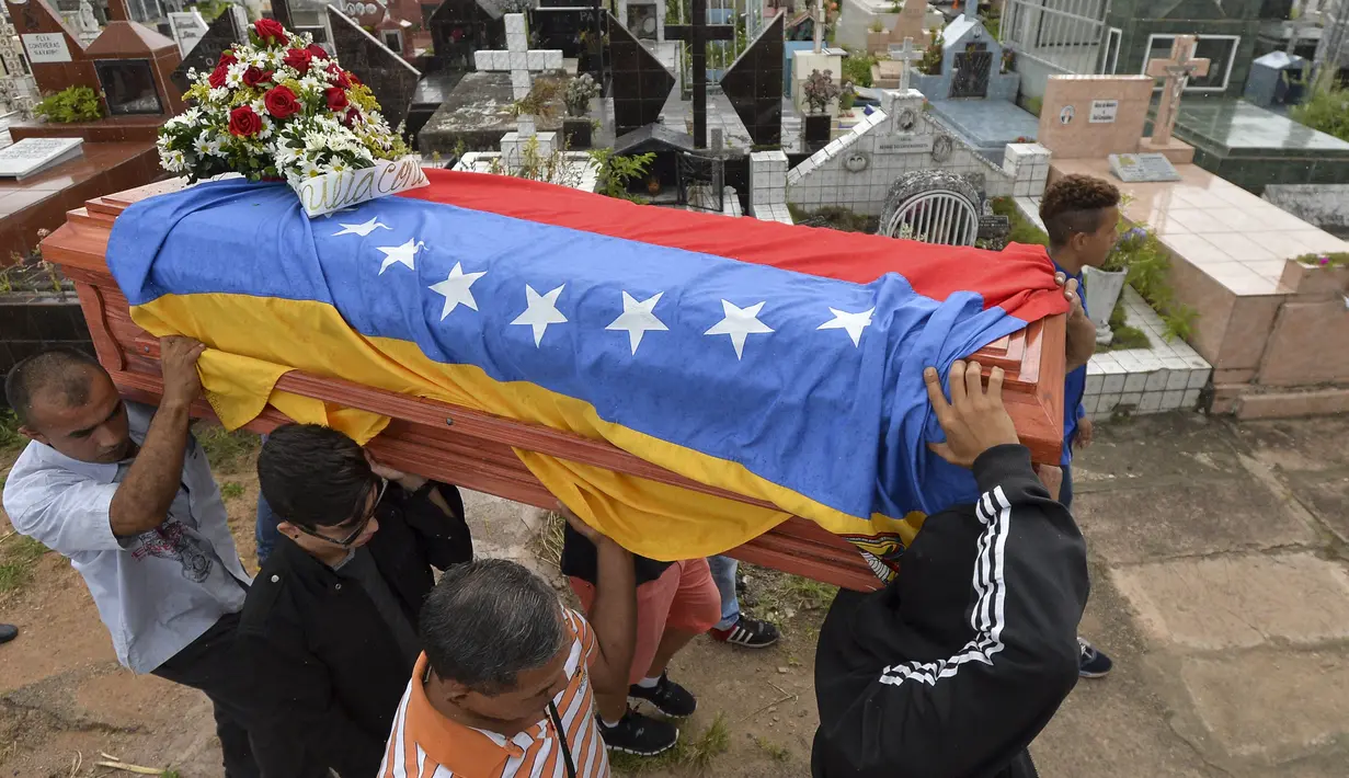 Keluarga dan kerabat mengantarkan jenazah Jose Francisco Guerrero untuk dimakamkan di San Cristobal, Tachira State, Venezuela (19/5). (AFP/Luis Robayo)