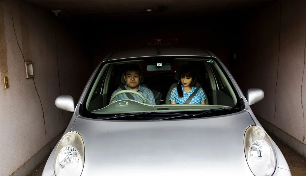 Ahli fisioterapi, Masayuki Ozaki mengendarai mobil bersama boneka seksnya, Mayu di Chiba, Jepang (13/6). Ozaki menganggap boneka seks bernama Mayu ini layaknya manusia. (AFP photo/Benrouz Mehri)