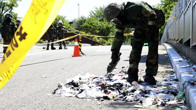 Tentara Korea Selatan yang mengenakan alat pelindung diri memeriksa sampah dari balon yang dikirim oleh Korea Utara di Incheon, Korea Selatan, Minggu (2/6/2024).